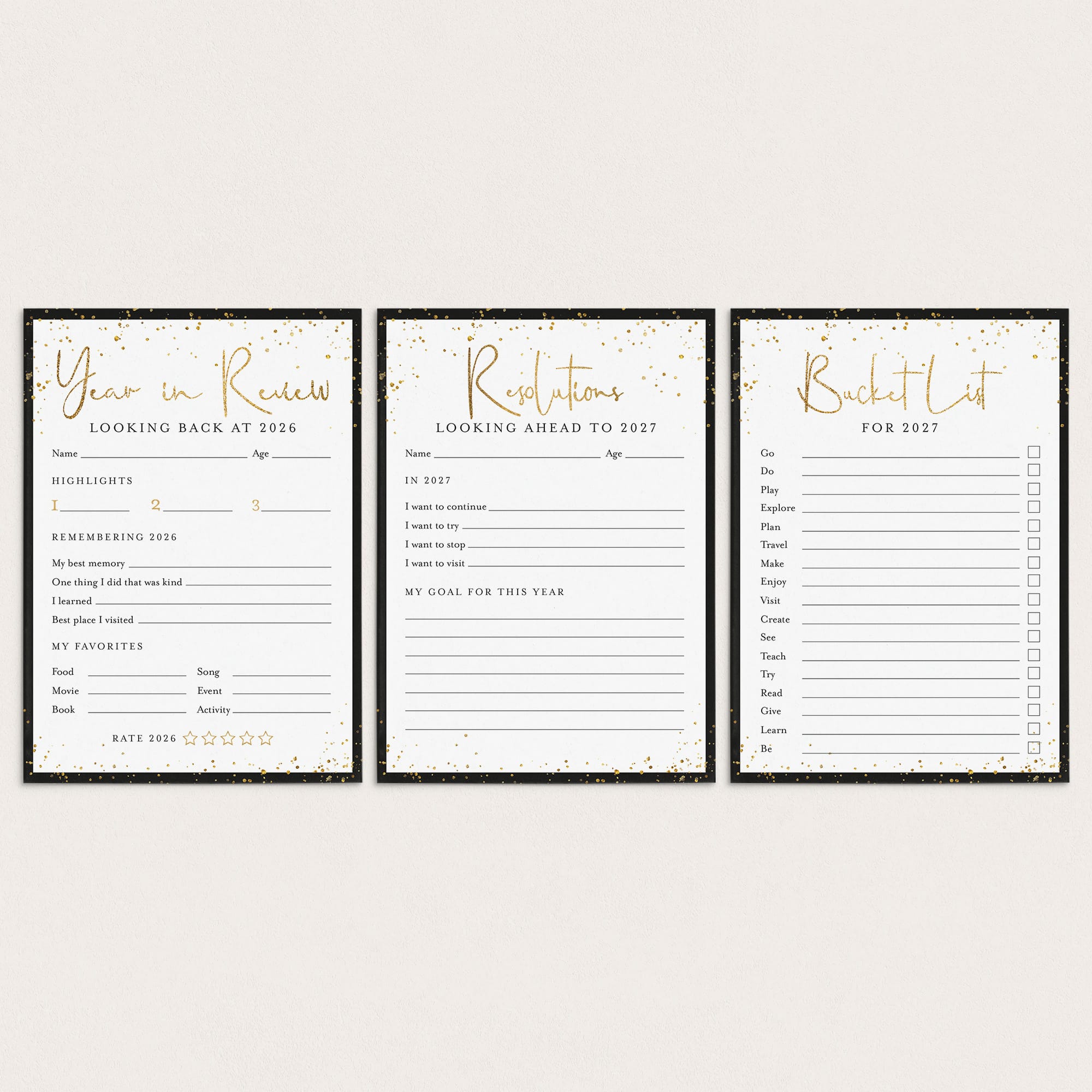 Three black and white stationery cards with gold foil accents, displayed side-by-side on a light beige background. The cards are labeled 'Year in Review', 'Resolutions', and 'Bucket List'.