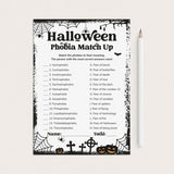 A printable Halloween-themed worksheet titled 'Halloween Phobia Match Up' with black text and spooky border graphics on a white sheet, shown on a light beige background with a white pencil beside it.