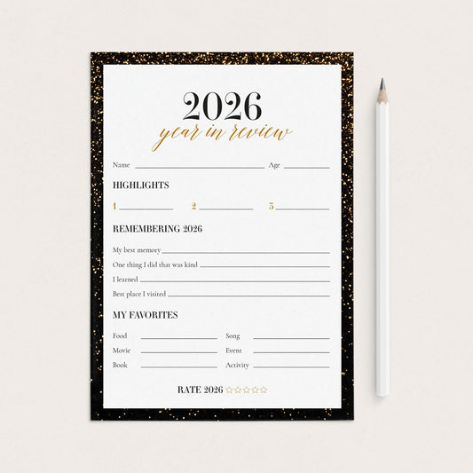 A 2026 year in review planner page with a black glitter border, shown on a light beige background next to a white pencil.