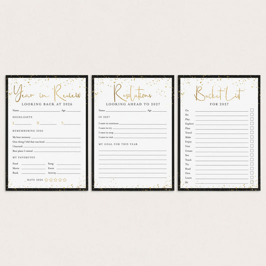 Three black and white stationery cards with gold foil accents, displayed side-by-side on a light beige background. The cards are labeled 'Year in Review', 'Resolutions', and 'Bucket List'.