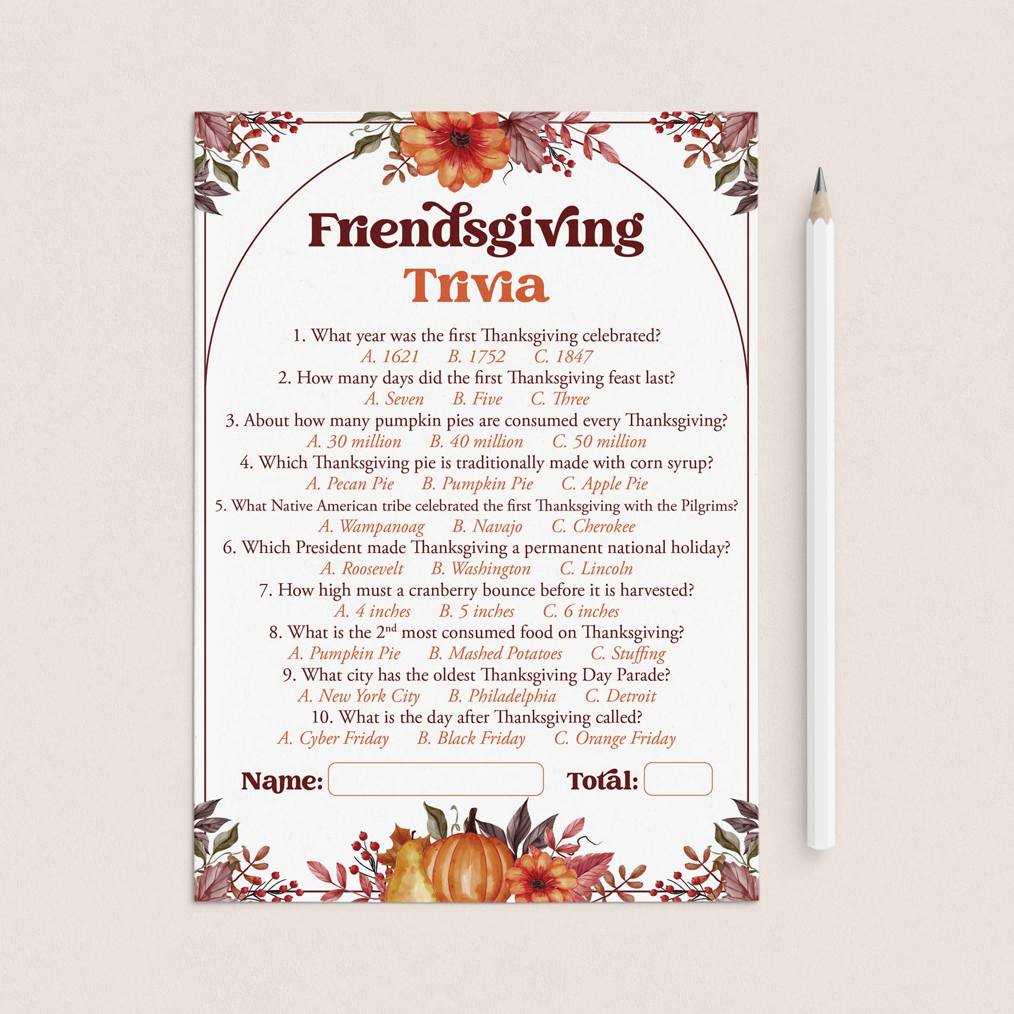 A Thanksgiving trivia game card with floral fall border illustrations, shown on a light beige background next to a white pencil. The card features a central arch with the title 'Friendsgiving Trivia' and ten multiple-choice questions with answer options listed below.